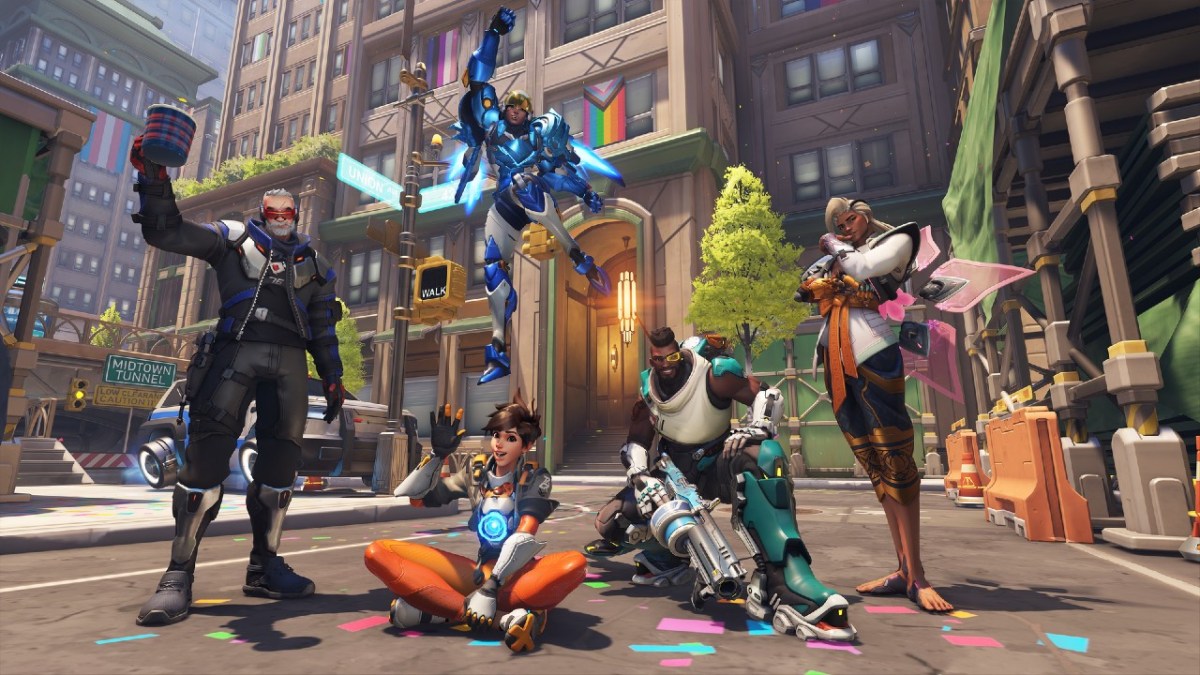 Soldier: 76, Pharah, Tracer, Baptiste, and Lifeweaver posing together with Pride decor in the background