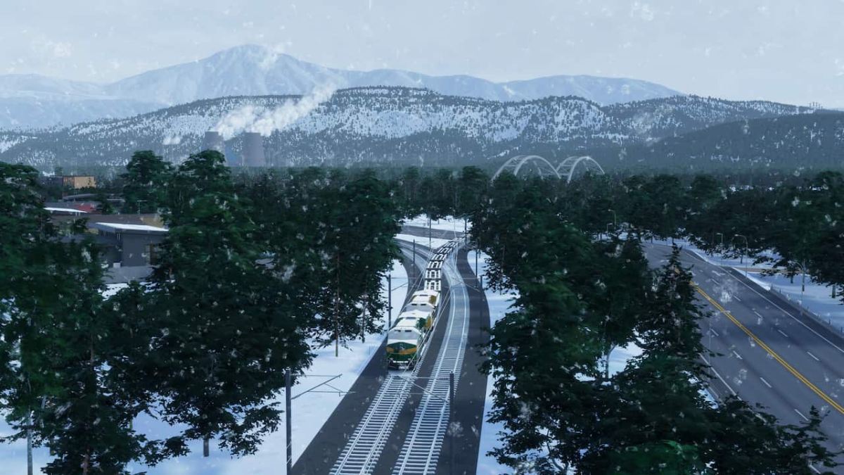 A train traveling down train tracks next to a snowwy highway.