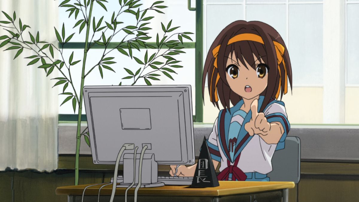 Haruhi-Suzumiya-sitting-at-a-desk-on-a-computer