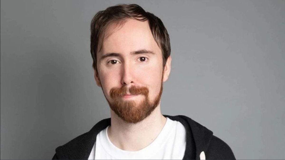 Asmongold-with-a-short-hair-style-smiling-against-a-greay-backdrop