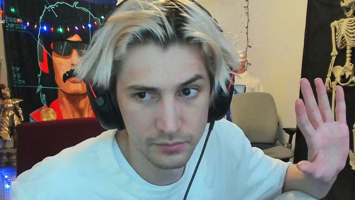 xQc holding his hand up to his camera during a live stream