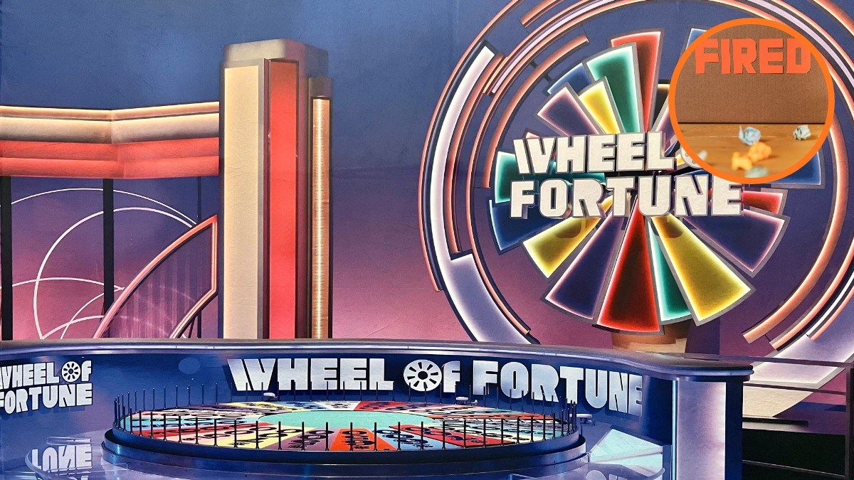 Wheel of Fortune game show set with an orange 'FIRED' graphic overlaid in the upper-right corner.